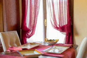 un tavolo con tende rosse e un tavolo con piatti di Santa Croce Resort a Torgiano Altre 21 foto