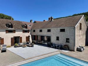 ein Haus mit einem Pool vor einem Haus in der Unterkunft Maison de Melin in Auxey-Duresses