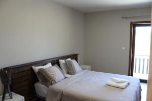 a bedroom with a bed with two towels on it at Quinta Do Marmeiral in Mangualde