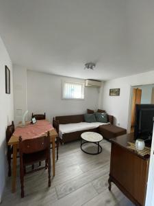 a living room with a couch and a table at Apartman Magdalena in Banja Koviljača +13 photos