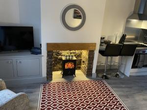 a living room with a fireplace and a television at Two bed holiday home in Conwy in Conwy