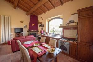 una cucina e una sala da pranzo con un tavolo e una sala da pranzo di Santa Croce Resort a Torgiano