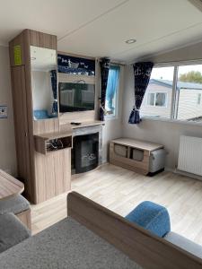 a living room with a tv and a couch at Blackpool caravans Marton mere in Blackpool