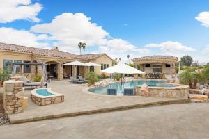 a backyard with a swimming pool and a house at Villa Bella - Private Estate in the Heart of Palm Desert, Outdoor Amenities, Gym, Game Room in Palm Desert