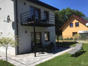 a house with a patio with a table and chairs at Apartamenty Black&White Lubawka - Domek z ruską banią i sauną in Lubawka