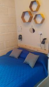 1 dormitorio con 1 cama azul y 2 almohadas en Triesti Home en Victoria