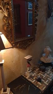 um espelho numa parede ao lado de uma mesa com uma estátua em Vivienda de uso turístico Domus Josefae em Salamanca