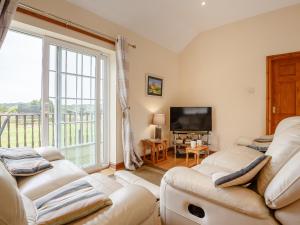 a living room with two couches and a large window at 3 Black Horse Cottages in Pentraeth