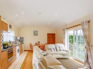 a living room with two couches and a kitchen at 3 Black Horse Cottages in Pentraeth