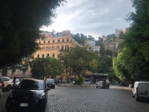 eine Stadtstraße mit Autos, die vor einem Gebäude geparkt sind in der Unterkunft Casa Amedeo in Neapel