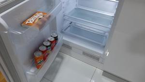 einen offenen Kühlschrank mit Getränken und Snacks in der Unterkunft Apartman 222 in Brčko