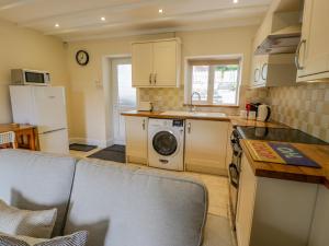 a kitchen with a washer and dryer in a room at Awelfryn in Betws-y-coed