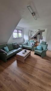 a living room with green couches and a coffee table at Ferienwohnung bei Natie in Brilon