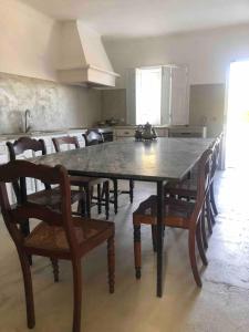 un grande tavolo da pranzo con sedie e una cucina di QUINTA DA CORTE a Santiago do Cacém