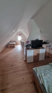 a white attic room with a bed and a tv at Ferienwohnung bei Natie in Brilon
