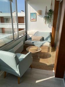 sala de estar con sofá y mesa en Appartement de standing, vue sur port de plaisance en La Baule