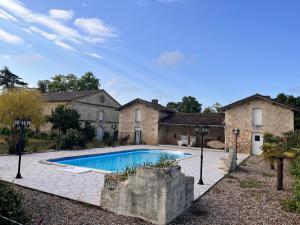 a house with a swimming pool in front of it at Maison de maître dans un parc clos de 3 hectares in Lamothe-Montravel