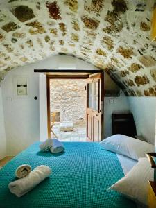 1 dormitorio con 1 cama con toallas en Vecchia Casa sterna, en Monemvasia