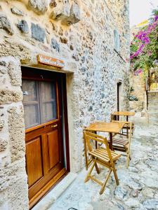 a wooden table and chairs sitting outside of a building at Vecchia Casa sterna in Monemvasia