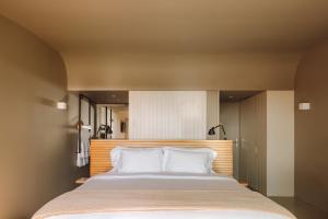 a bedroom with a large bed with white pillows at Immerso Hotel, a Member of Design Hotels in Ericeira