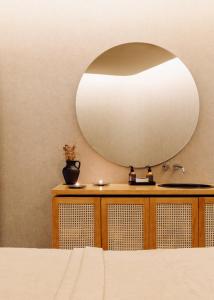a bedroom with a large mirror above a bed at Immerso Hotel, a Member of Design Hotels in Ericeira