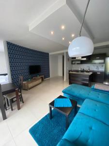 sala de estar con sofás azules y cocina en JAB Apartments Bandurskiego Business & Family en Szczecin