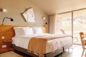 a bedroom with a bed and a sliding glass door at Immerso Hotel, a Member of Design Hotels in Ericeira