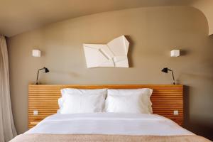 a bedroom with a bed with two lights on the wall at Immerso Hotel, a Member of Design Hotels in Ericeira