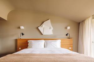 a bedroom with a bed with a wooden headboard at Immerso Hotel, a Member of Design Hotels in Ericeira