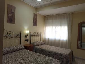 a bedroom with two beds and a window at Hotel Beatriz in Burriana