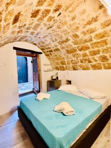 a bedroom with a bed in a stone wall at Vecchia Casa kamara in Monemvasia