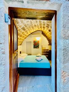 a bedroom with a bed in a brick wall at Vecchia Casa kamara in Monemvasia