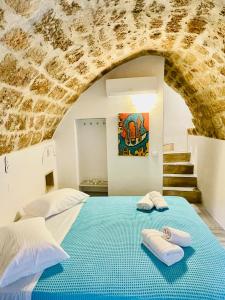 a bedroom with two beds and a stone wall at Vecchia Casa kamara in Monemvasia