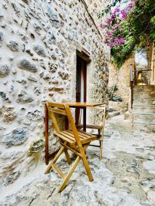 莫奈姆瓦夏的住宿－Vecchia Casa kamara，一张木椅,坐在石头建筑前