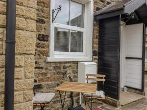 una mesa y sillas junto a un edificio con ventana en 5 East Street, en Skipton