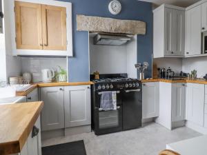 a kitchen with white cabinets and a black stove top oven at 5 East Street in Skipton