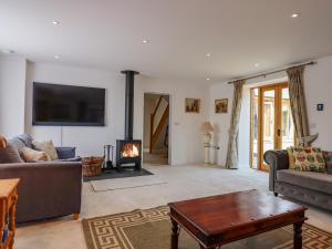 a living room with a couch and a fireplace at The Tithe Barn in South Molton