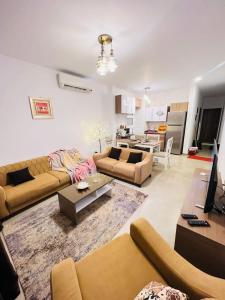 sala de estar con 2 sofás y cocina en Amwaj Seaside Retreat- Luxury 2BR Chalet in Amwaj Sidi Abdelrahman, en El Alamein