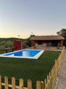 ein Pool vor einem Haus mit einem Zaun in der Unterkunft Cigarra Sierra in Córdoba
