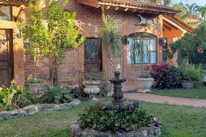 a brick house with a fountain in the yard at Casita Jardin de Mariposas El Tuito in El Tuito