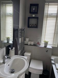 a white bathroom with a sink and a toilet at Lovely 2-bedroom apartment in Zone 2 London in London
