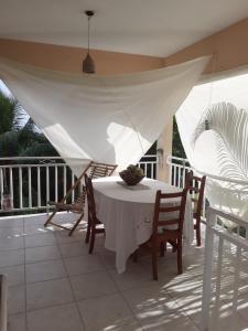 a table and chairs on a porch with a white canopy at JOYAUX DE TIVOLI VILLA in Fort-de-France
