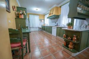 a kitchen with green cabinets and a tile floor at VILLA CAPITAN in Sanlúcar de Barrameda