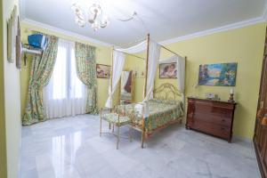 a bedroom with a canopy bed and a wooden dresser at VILLA CAPITAN in Sanlúcar de Barrameda