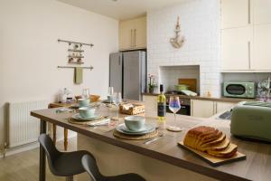 uma cozinha com uma mesa com pão em Modern, light and airy townhouse in Llandudno, West Shore em Llandudno