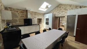 a kitchen with a table with chairs and a refrigerator at Terra Alta do Furnia in Tui
