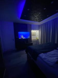 um quarto escuro com uma cama e uma televisão em Festival Centar Sarajevo em Sarajevo
