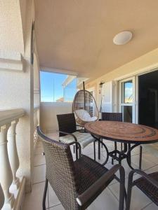 balkon ze stołem i krzesłami na ganku w obiekcie Porto fino almerimar w Almerimar