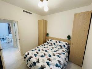 Schlafzimmer mit einem Bett mit einer blauen und weißen Bettdecke in der Unterkunft NICE CENTRIC APARTMENT in Vilanova i la Geltrú