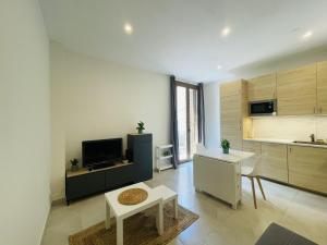 ein Wohnzimmer mit einer Küche und einem Tisch in der Unterkunft NICE CENTRIC APARTMENT in Vilanova i la Geltrú